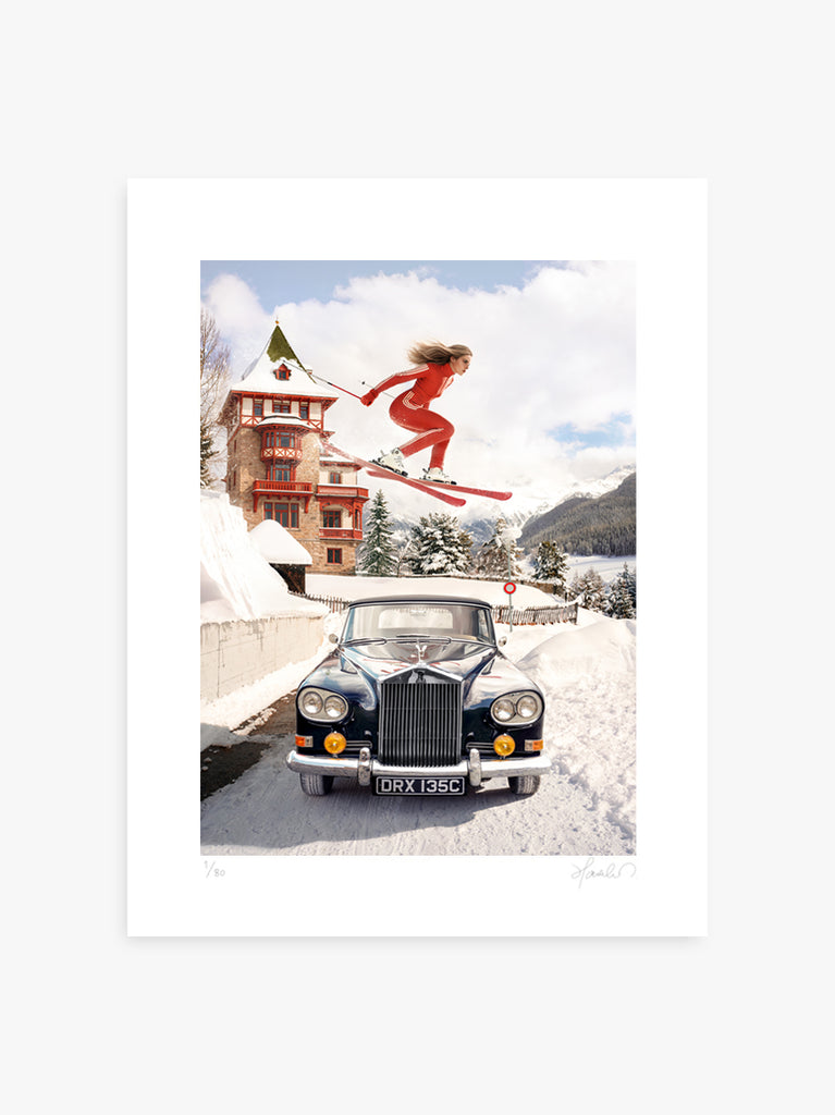 A woman in vintage ski attire soars gracefully over a classic Rolls-Royce in the snowy Alps in The Alpine Jump, a Signed Limited Edition fine art print by Paul Fuentes,  a surreal blend of elegance, adventure, and cinematic winter style.
