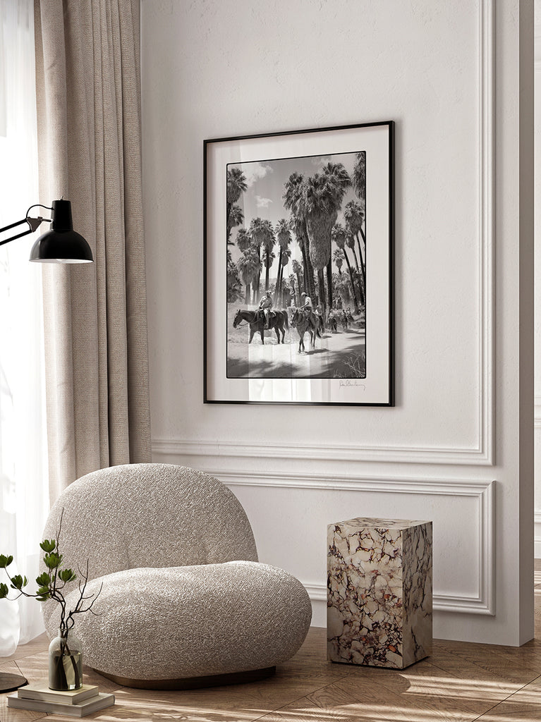 framed artwork of Black and white fine art photograph of cowboys on horses between tall palm trees in Palm Springs, California. part of Paul Fuentes’ minimal and elegant Black & White Collection.