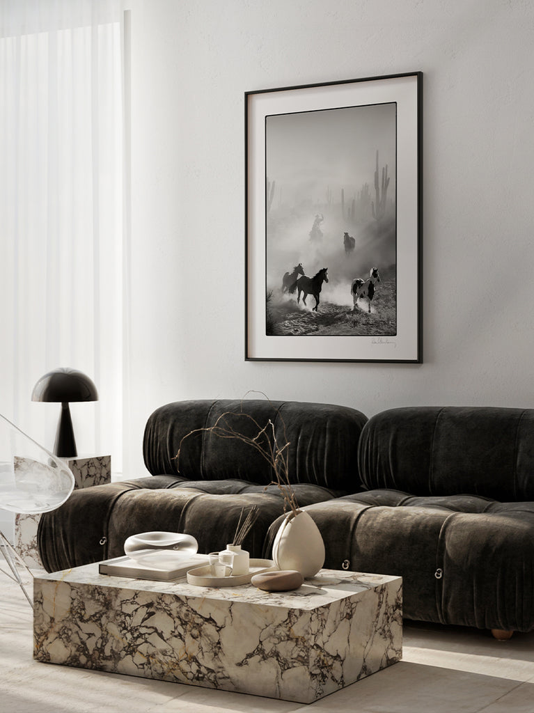 interior with framed artwork. Black and white fine art photograph of wild horses and cowboys in the desert, part of Paul Fuentes’ Black & White Collection.