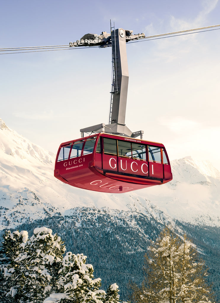 Art print featuring a red cable car with the brand name 'Gucci' on it, traveling over a snowy mountain landscape fine art photography by Paul Fuentes.
