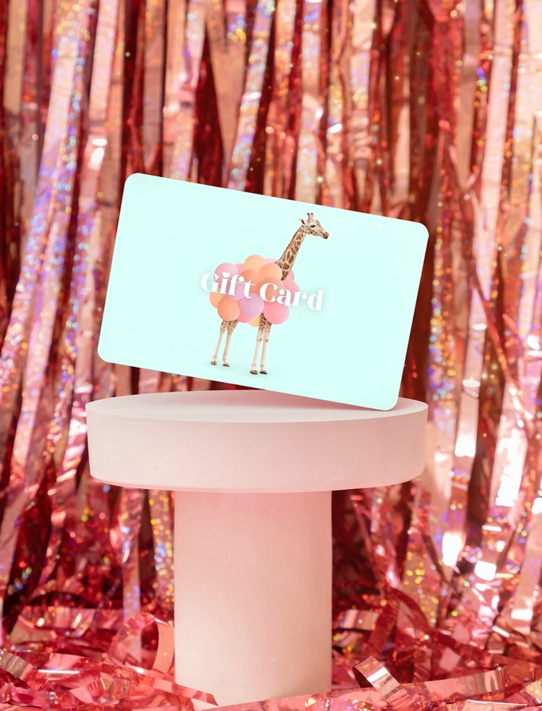 A gift card with a giraffe illustration presented on a stand with a shiny, sparkling background.