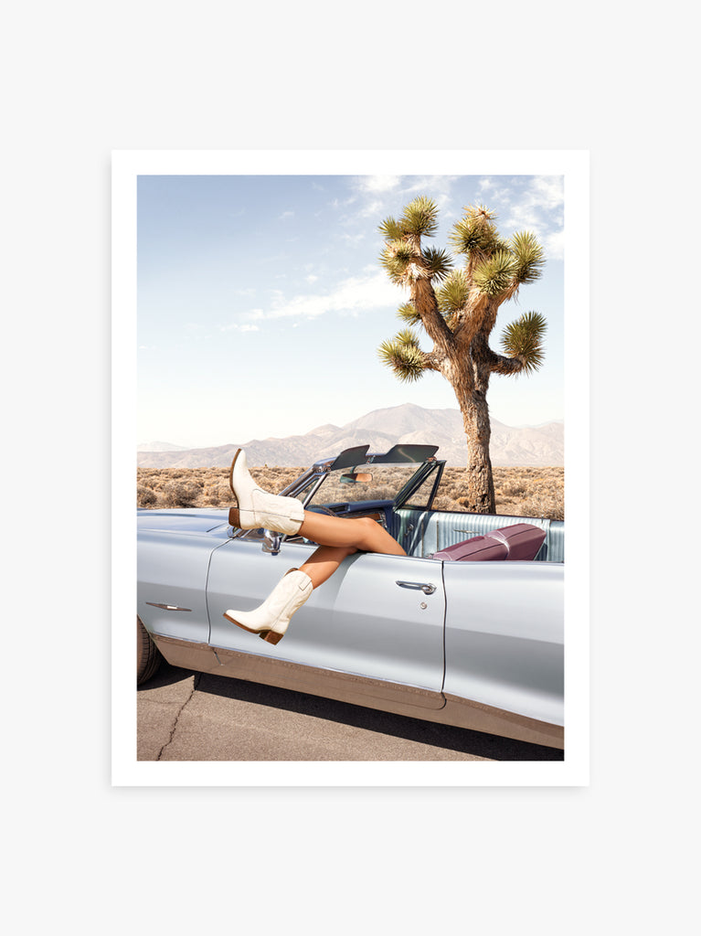 Cowboy boots in Joshua Tree desert scene and classic car. A surreal fine art photograph by Paul Fuentes.