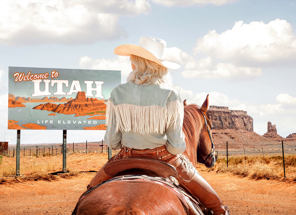 Photograph by Paul Fuentes featuring a cowgirl on horseback with a 'Welcome to Utah' sign in the background, set against a desert landscape.