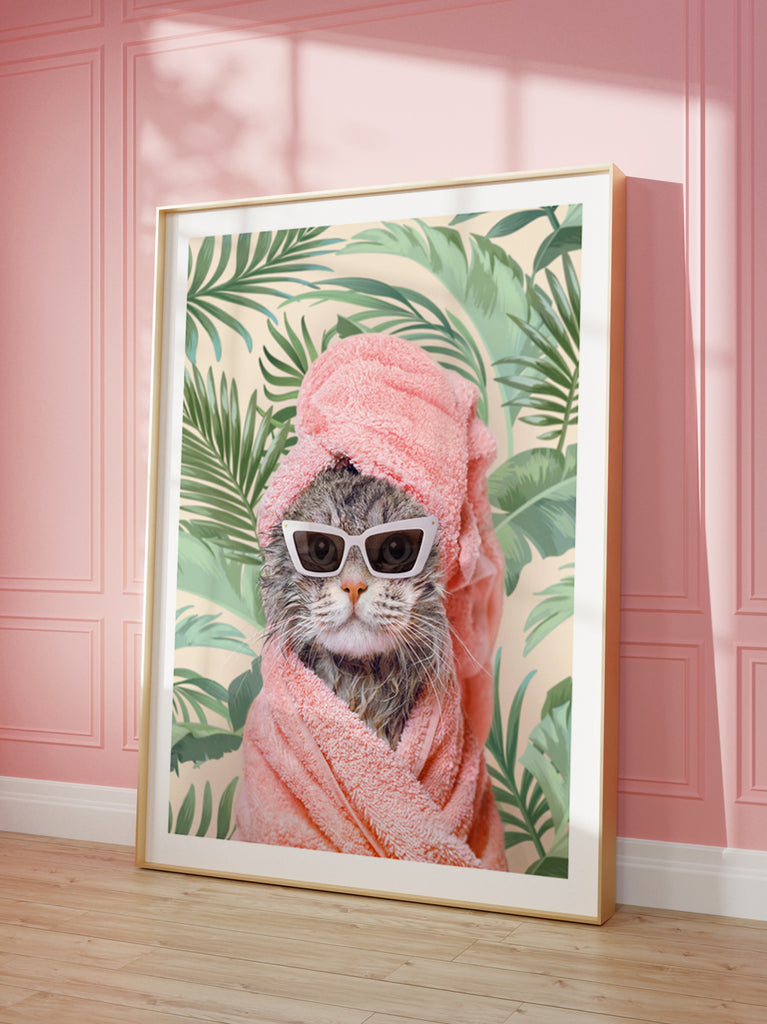 framed artwork by paul fuentes of a cat with sunglasses and a pink towel, set against a background with green leaf patterns.