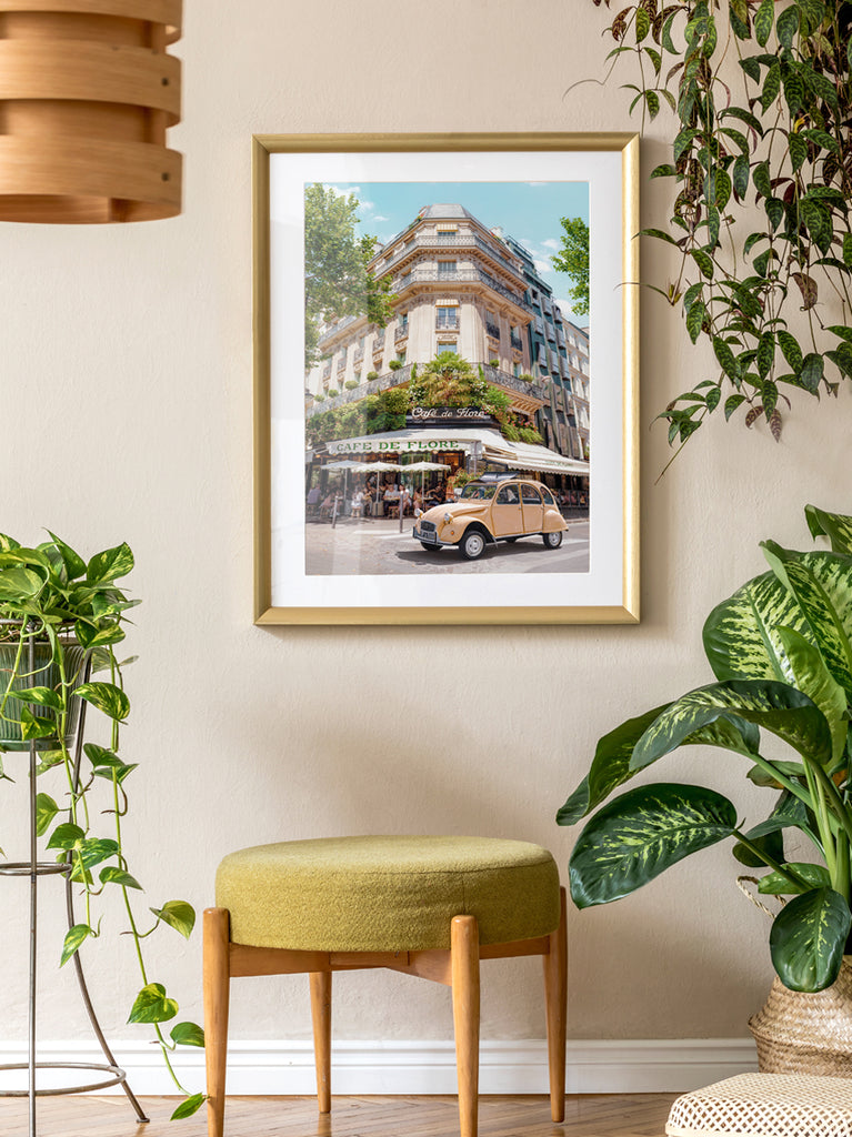 Framed wall art by Paul Fuentes featuring a classic image of the Cafe de Flore in Paris with a vintage car parked in front. 