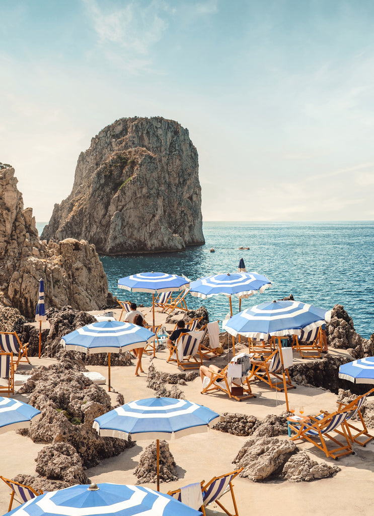 Capri beach scene with blue and white umbrellas and turquoise sea, fine art photograph by Paul Fuentes.