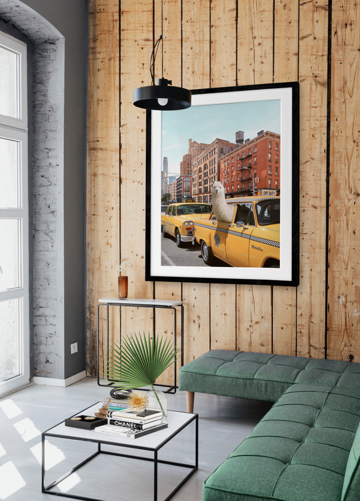 artwork on wood wall of an alpaca sticking its head out of a yellow taxi window in a urban setting of New York with buildings in the background. Photography by Paul Fuentes