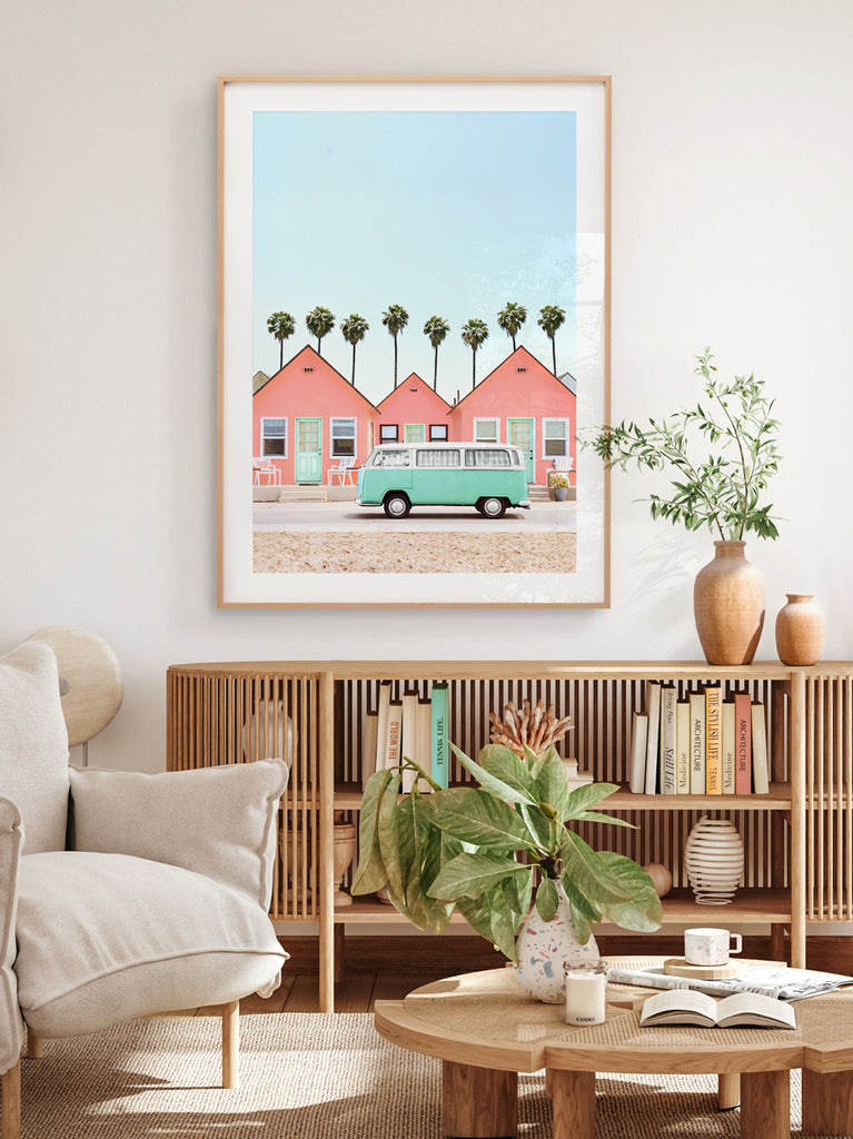 interior with a colorful artwork featuring pink beach cottages and a vintage green car with palm trees in the background, fine art photography by Paul Fuentes