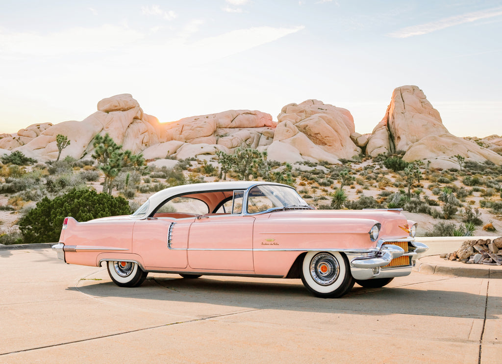 Pink Cadillac parked in pastel desert landscape, fine art photography by Paul Fuentes.