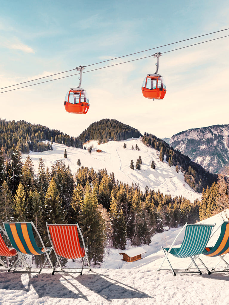 Artistic representation of luxurious winter chairs with a snowy mountain landscape in the background, including ski lifts and a clear blue sky. fine art photography by Paul Fuentes.